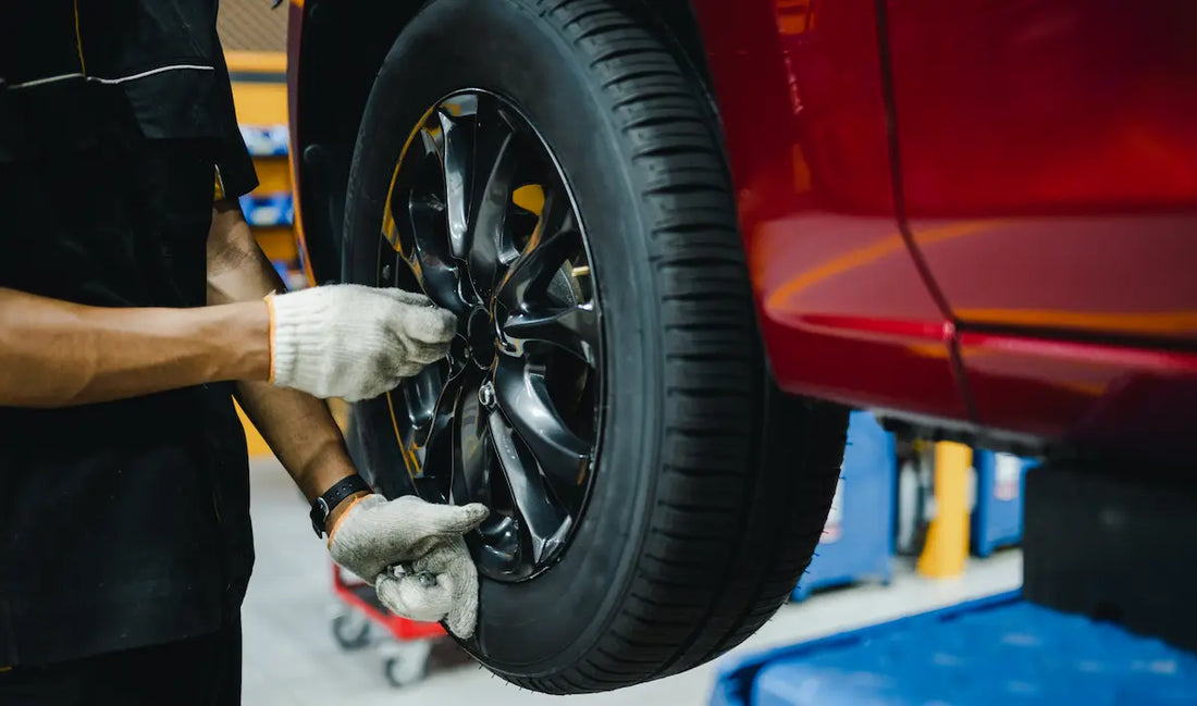 Wheel alignment Singapore technician inspecting and adjusting a vehicle wheel during a professional alignment service
